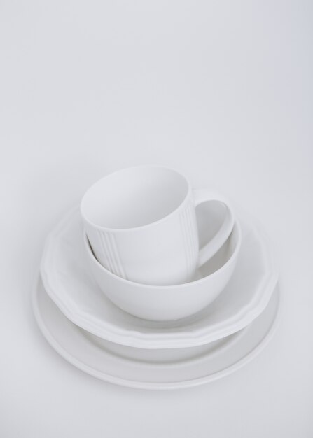białe naczynia trzy talerze i kubek na białym tle