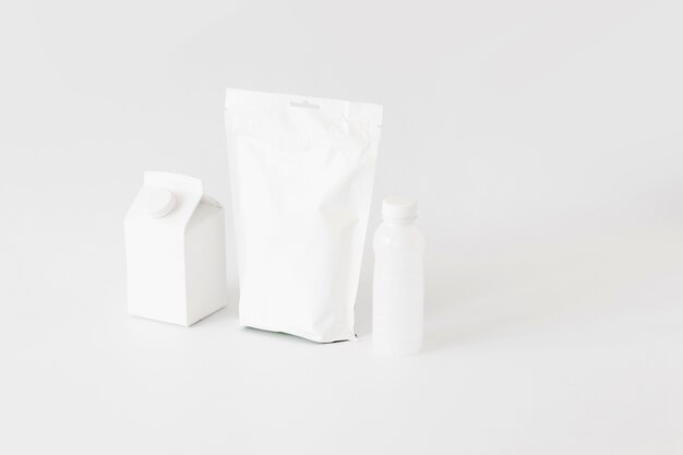 Białe opakowania kartonowe i butelki na produkty mleczarskie