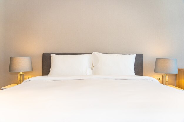Białe poduszki na łóżku z lampkami