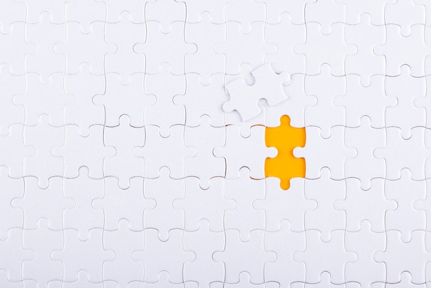 Bezpłatne zdjęcie białe puzzle i żółte tło widok z góry