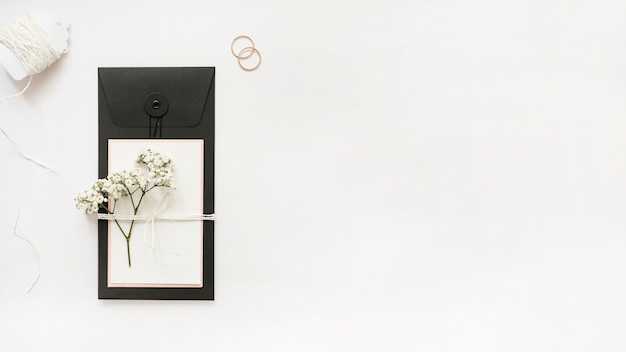 Bezpłatne zdjęcie białe struny; obrączki ślubne i kartkę z życzeniami z oddech dziecka kwiaty na białym tle