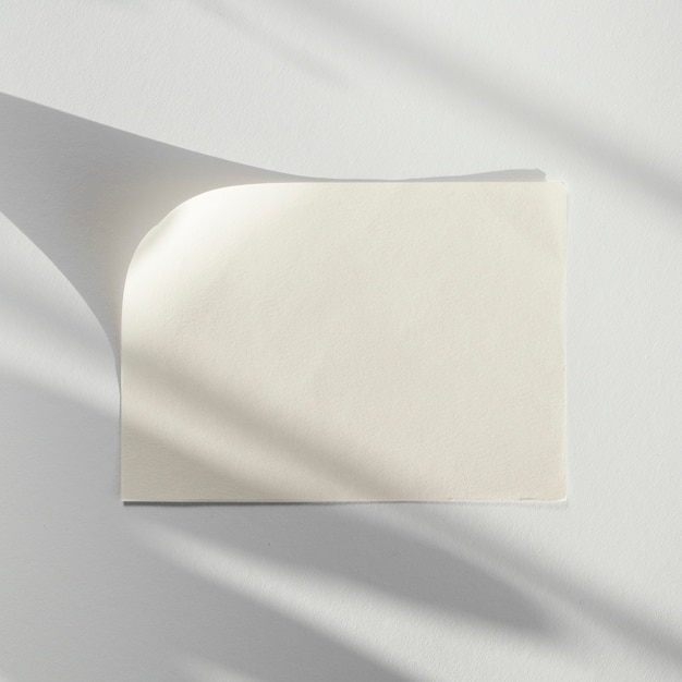 Bezpłatne zdjęcie białe tło z białą kartką papieru z cieniem