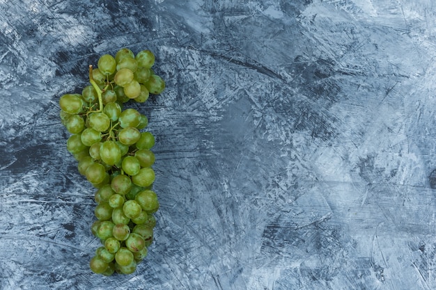 Bezpłatne zdjęcie białe winogrona leżały płasko na ciemnoniebieskim tle marmuru. poziomy