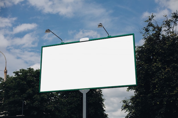 Biały billboard na zielonych liściach