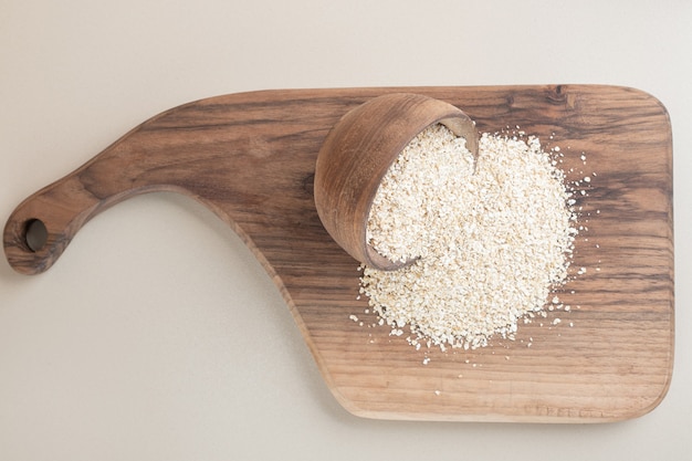 Biały ryż w drewnianej filiżance na drewnianym talerzu.