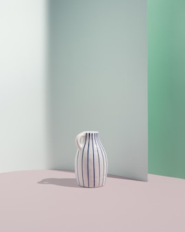 Biały wazon retro z niebieskimi paskami na pastelowych turkusowych tłach. projektowanie wnętrz copyspace, rama magazynów. estetyczna, nowoczesna koncepcja minimalistycznego wzornictwa.