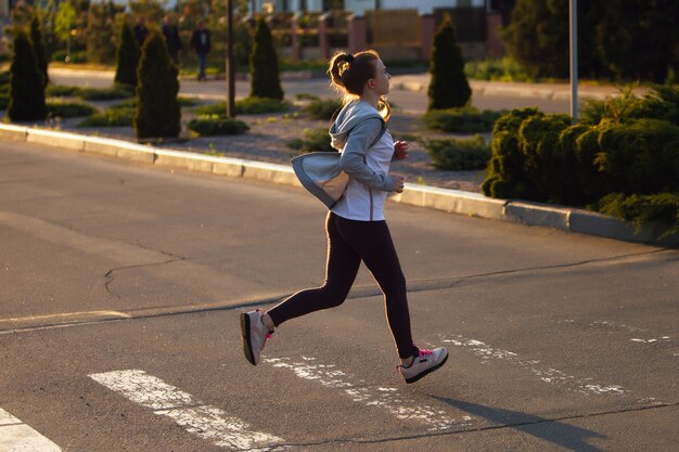 Biegacz sportowiec działa na drodze. kobieta fitness jogging koncepcja treningu odnowy biologicznej.