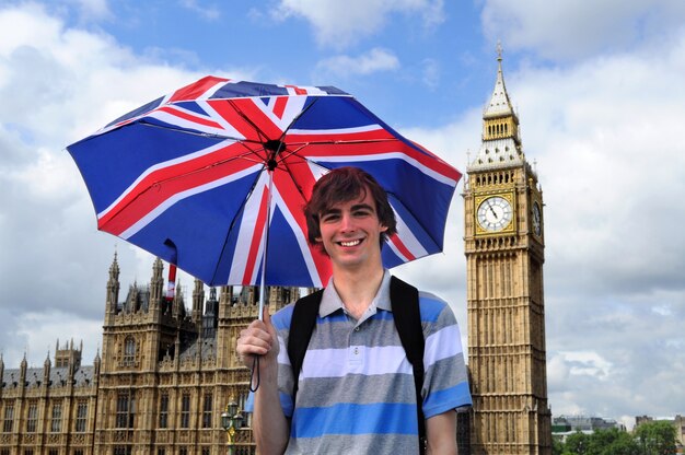 Big Ben i turystyczny z brytyjskiej flagi parasolem w Londynie