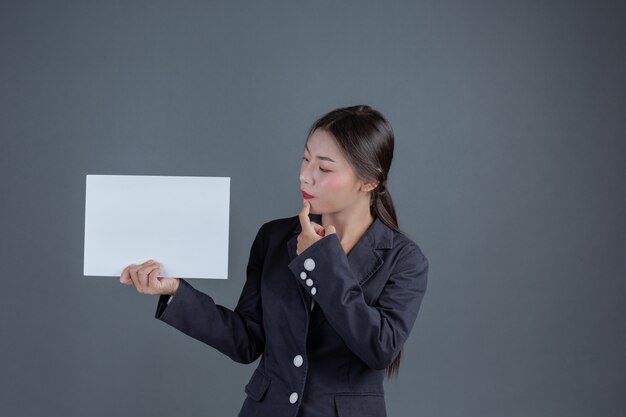 Biurowa dziewczyna trzyma białą puste miejsce deskę
