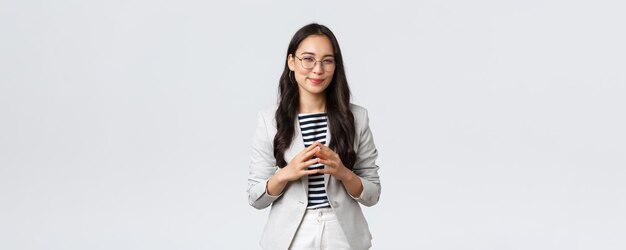Biznes, finanse i zatrudnienie, przedsiębiorca i koncepcja pieniędzy Kreatywna młoda azjatycka bizneswoman ma sprytny pomysł, myśli, intryguje lub przygotowuje plan, mrużąc oczy przed kamerą zainteresowana