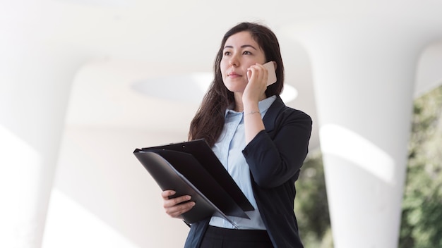 Biznes kobieta rozmawia telefon niski kąt