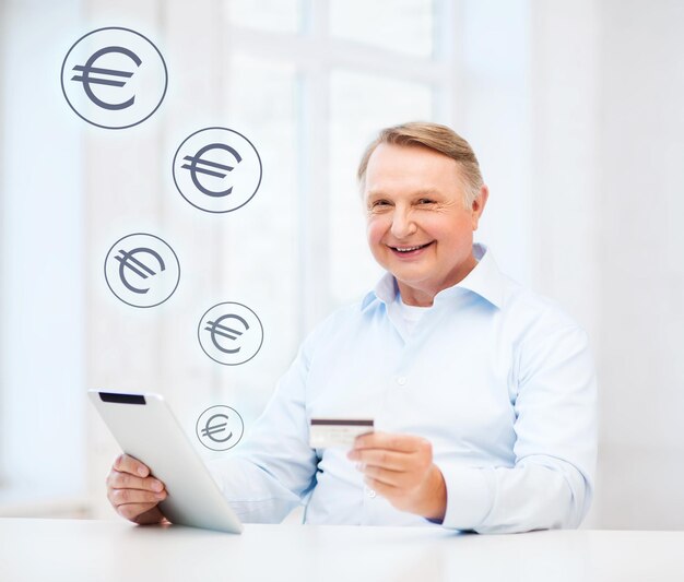 Biznes, Starość, Bankowość Online, Zakupy Internetowe I Koncepcja Starości - Uśmiechnięty Staruszek Z Tabletem I Kartą Kredytową W Domu Premium Zdjęcia