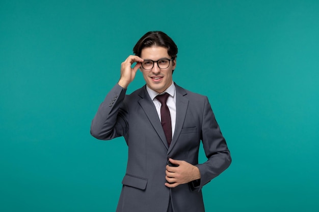 Biznesmen ładny młody przystojny mężczyzna w szarym garniturze biurowym i krawacie dotykającym rogu okularów
