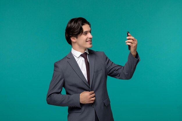 Biznesmen ładny młody przystojny mężczyzna w szarym garniturze biurowym i krawacie robi selfie