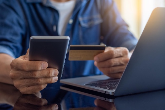 Biznesmen ręka za pomocą telefonu komórkowego i karty kredytowej do zakupów online i płatności