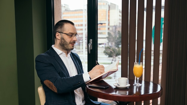 Bezpłatne zdjęcie biznesmen robi notatkom w notatniku