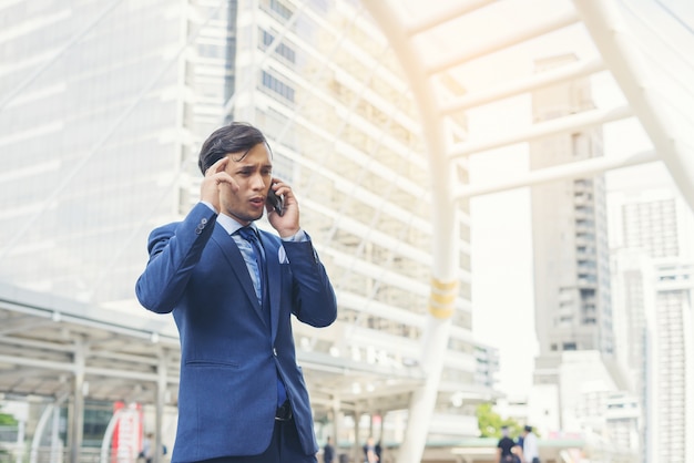 Biznesmen Rozmawia Przez Telefon Komórkowy Przeciwko Budynku Na Zewn? Trz.