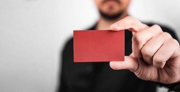 Biznesmen trzyma czerwoną pustą wizytówkę