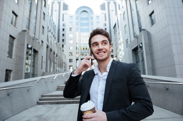 Biznesmen trzyma kawę i telefon