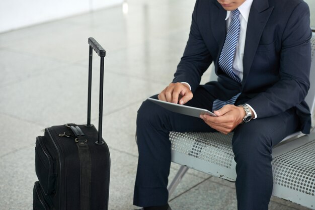 Biznesmen używa pastylka komputer w lotnisku