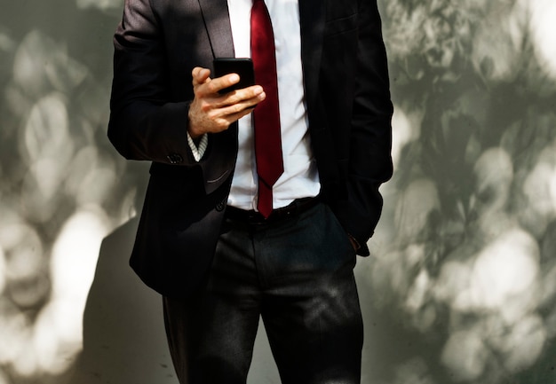Bezpłatne zdjęcie biznesmen używa telefon komórkowy technologię komunikacyjną