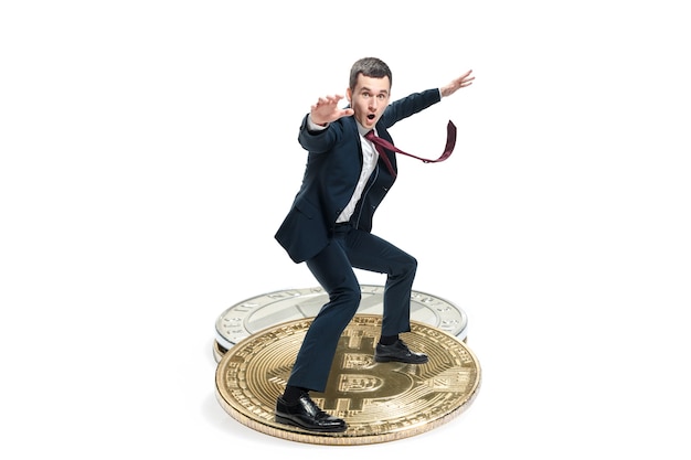 Bezpłatne zdjęcie biznesmen w garniturze stojący na ikonę wielkiego biznesu. męska figura i litecoin na białym tle. kryptowaluta, bitcoin, ethereum, e-commerce, koncepcja finansów. kolaż
