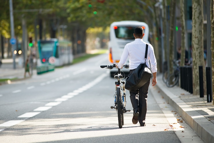 Bezpłatny plik Zdjęcie biznesmen walking z bike w ulicy po pracy