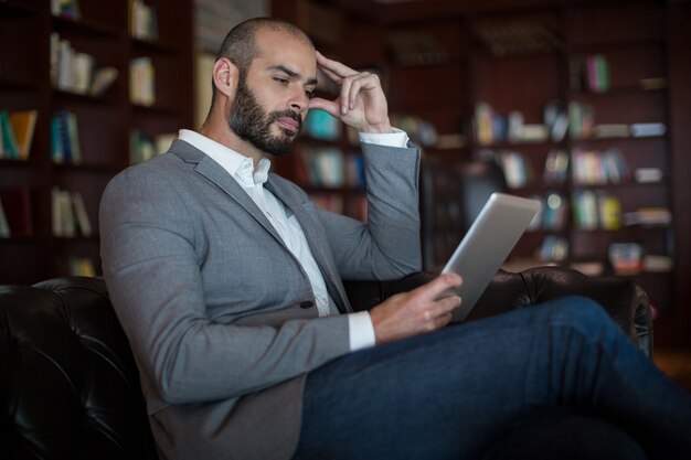 Biznesmen za pomocą cyfrowego tabletu w poczekalni