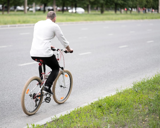 Bezpłatne zdjęcie biznesmena jeździecki bicykl na ulicie