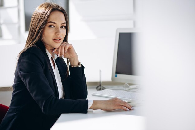 Biznesowa kobieta pracuje na komputerze w biurze