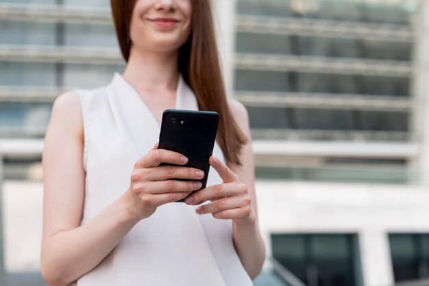 Biznesowa kobieta używa smartphone w ulicie