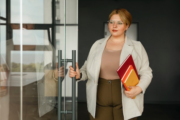 Bezpłatne zdjęcie biznesowa kobieta w dużych rozmiarach pracująca w profesjonalnym biurze
