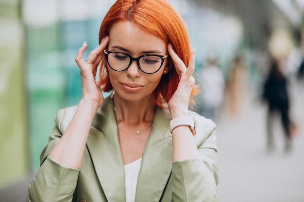 Biznesowa kobieta w widowiskach ma headcahe