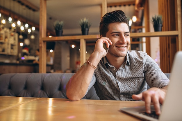 Biznesowy mężczyzna opowiada na telefonie w kawiarni