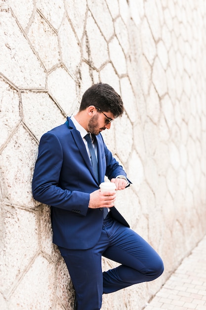 Bezpłatne zdjęcie biznesowy mężczyzna patrzeje jego zegarek