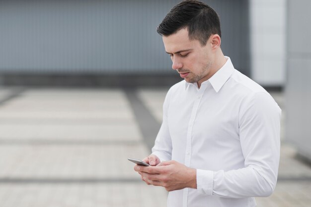 Bezpłatne zdjęcie biznesowy mężczyzna sprawdza telefon