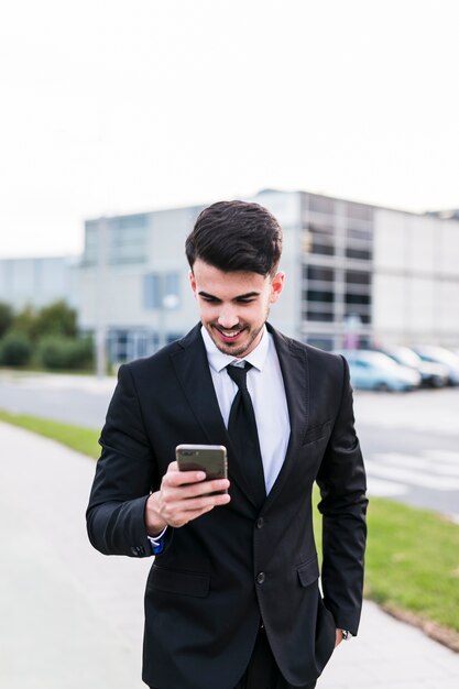 Biznesowy mężczyzna używa jego telefon