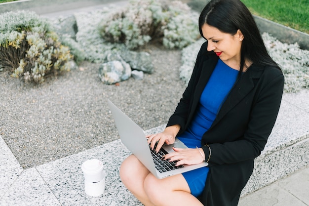 Bizneswoman pracuje na laptopie przy outdoors