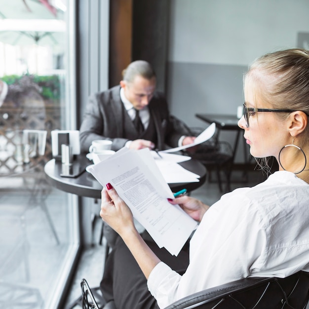 Bizneswoman sprawdza dokumenty w restauraci