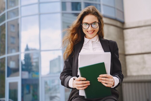 Bizneswoman stoi outdoors w miasto budynku biurowym