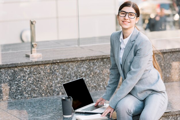 Bizneswoman używa laptop outdoors