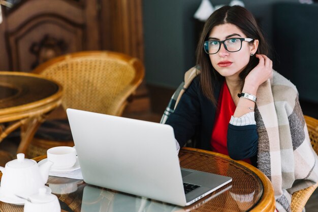 Bizneswoman używa laptop w sklep z kawą