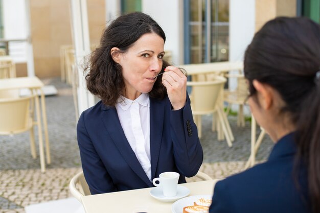 Bizneswomanu jedzenia deser i patrzeć