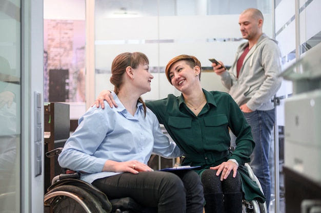 Bizneswomany na wózku inwalidzkim przy biurem