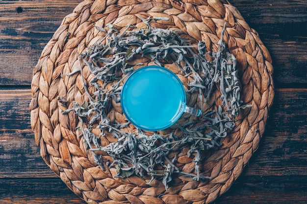 Bezpłatne zdjęcie błękit barwiąca woda w trójniaku z herbacianym odgórnym widokiem na ciemnym drewnianym tle