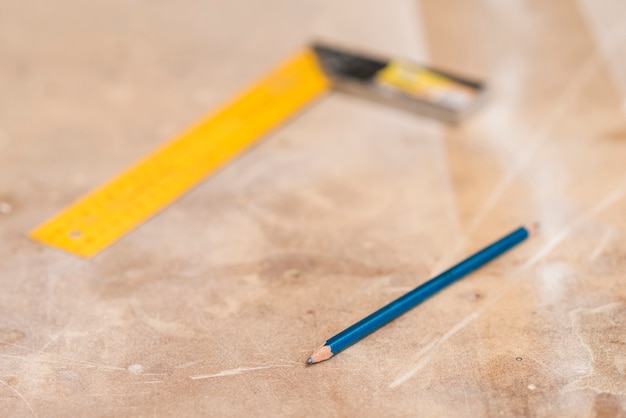 Bezpłatne zdjęcie błękitny ołówek i zamazana władca na drewnianej powierzchni