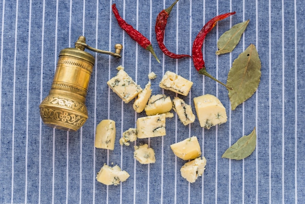 Bezpłatne zdjęcie błękitny ser blisko suchego czerwonego pieprzu i liści
