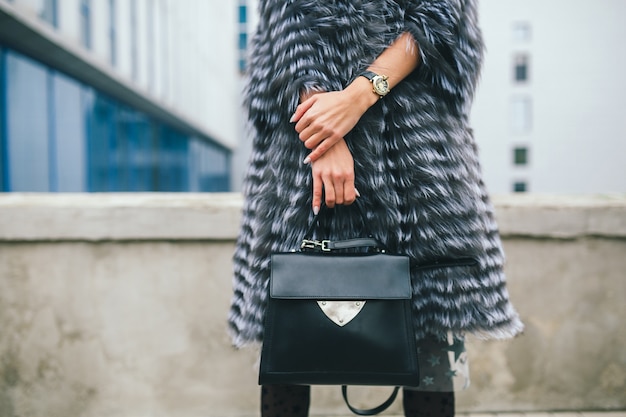 Bliska akcesoria szczegóły stylowej kobiety spacerującej po mieście w ciepłym futrze, trzymając czarną skórzaną torbę, sezon zimowy,