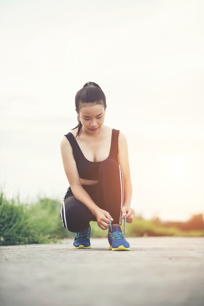 Bliska buty Kobieta biegacz wiązanie jej buty do ćwiczeń joggingowych