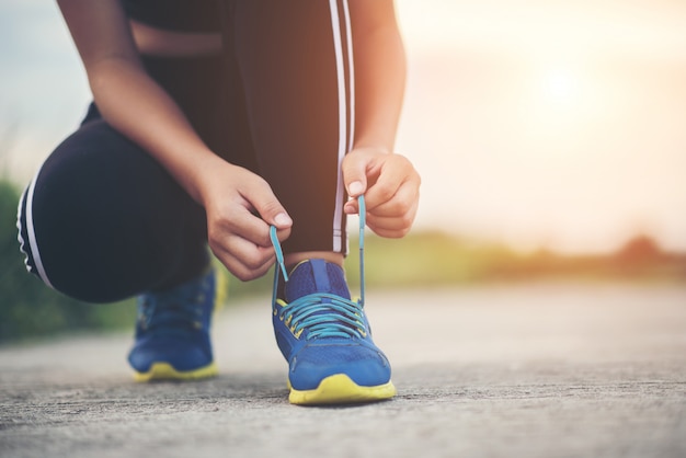 Bezpłatne zdjęcie bliska buty kobieta biegacz wiązanie jej buty do ćwiczeń joggingowych